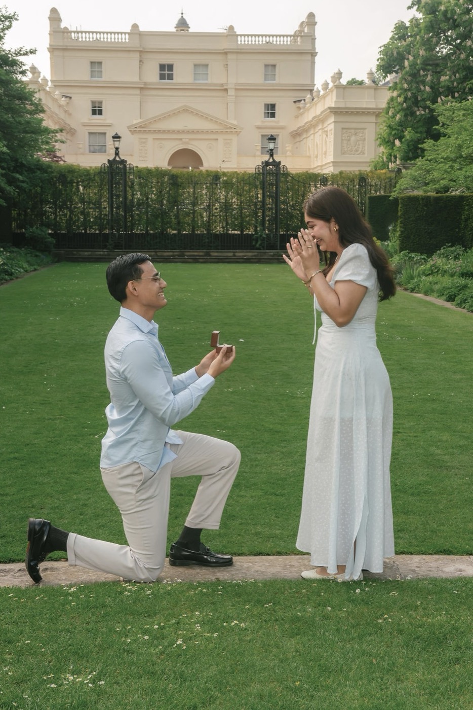 Osiel arrodillado pidiéndole matrimonio a Melissa en los jardines de Londres